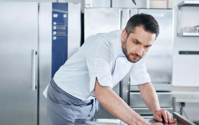 chef inspecting surface in large kitchen