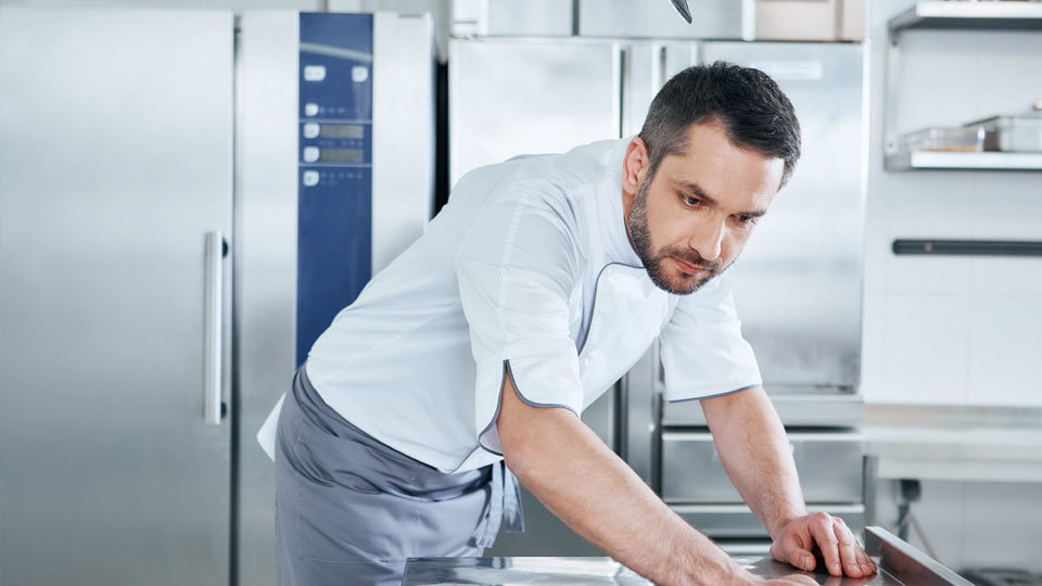 chef inspecting surface in large kitchen
